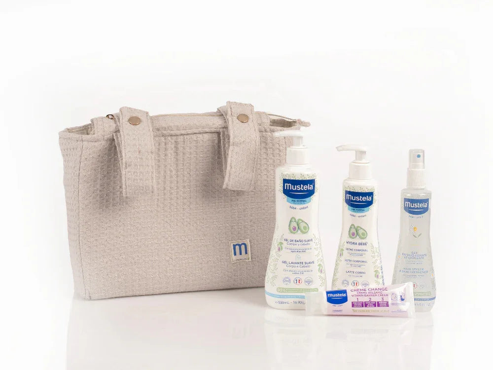 Bolsa de paseo rosa de Mustela con productos esenciales de aguacate bio para la higiene y cuidado del bebé.
